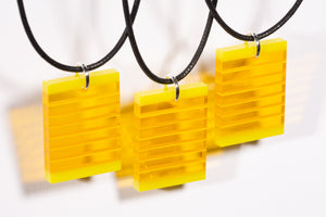 Fused, cut, and polished yellow glass layer pendants