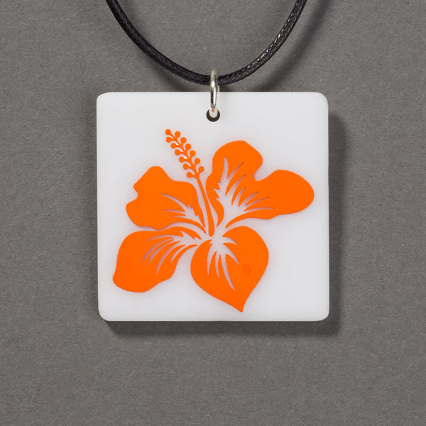 Sandcarved bright orange and white glass hibiscus flower pendant.