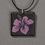 Sandcarved purple and black glass hibiscus flower pendant.