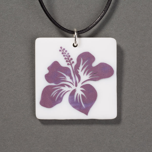 Sandcarved purple and white glass hibiscus flower pendant.