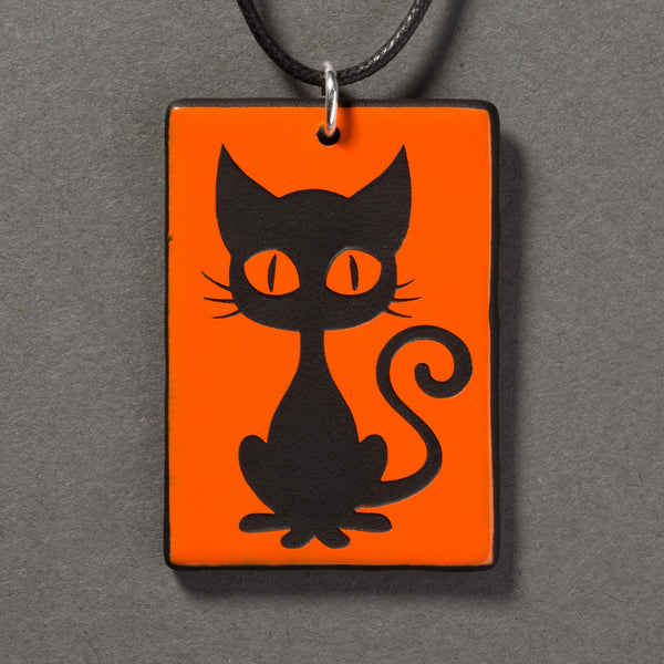 Sandcarved bright orange and black glass kitty pendant.