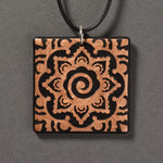 Sandcarved bronze and black glass mehndi mandala pendant.