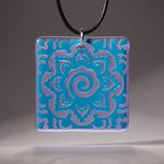 Sandcarved deep sky blue and lavender transparent glass mehndi mandala pendant.