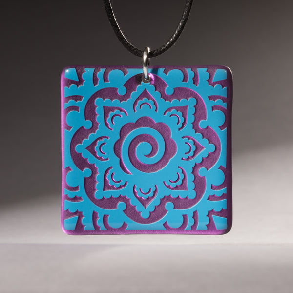 Sandcarved deep sky blue and violet transparent glass mehndi mandala pendant.