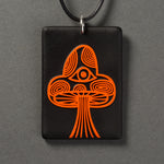 Sandcarved bright orange and black glass mushroom pendant.