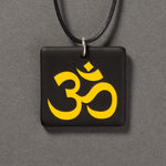 Sandcarved yellow and black glass om pendant.
