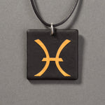 Sandcarved gold and black glass pisces pendant.
