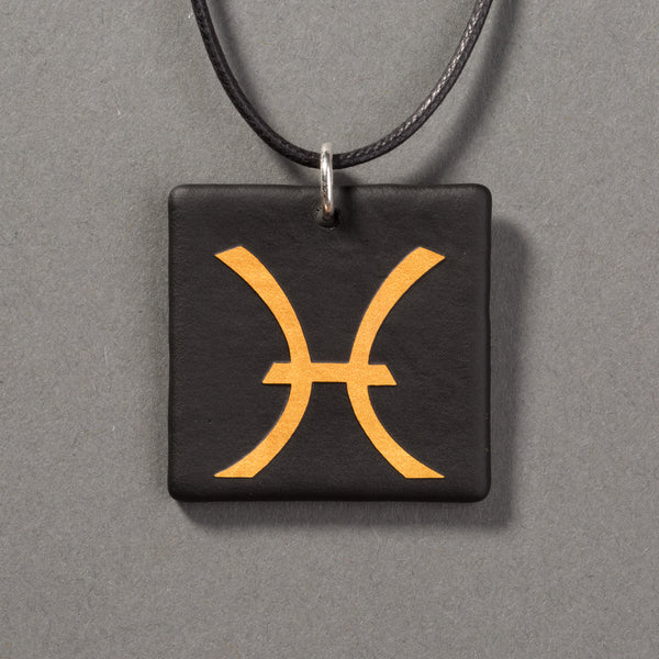Sandcarved gold and black glass pisces pendant.