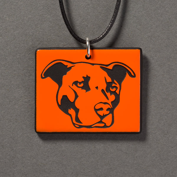 Sandcarved bright orange and black glass pit bull pendant.