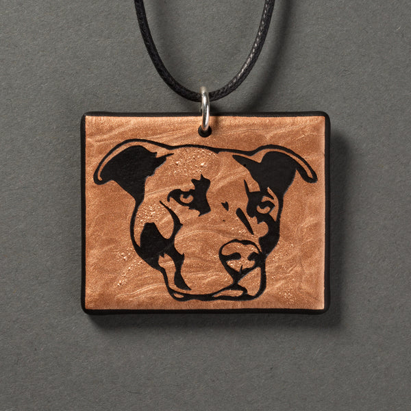 Sandcarved bronze and black glass pit bull pendant.