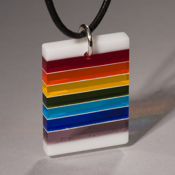 Cut and polished rainbow and white glass pendant.
