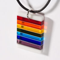 Cut and polished rainbow and white glass pendant.
