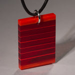 Cut and polished red and red transparent glass pendant.