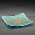 Sandcarved gold and cyan glass sun swimmer plate.