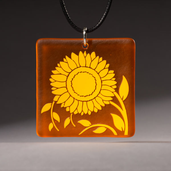 Sandcarved yellow and orange transparent glass sunflower pendant.