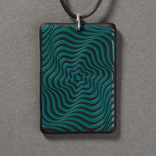 Sandcarved aquamarine and black glass vortex pendant.