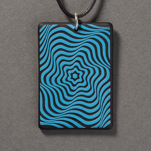 Sandcarved deep sky blue and black glass vortex pendant.