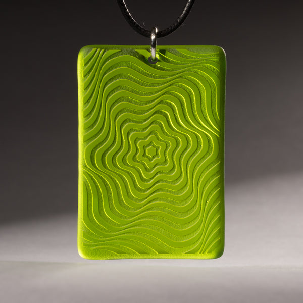 Sandcarved lime green and green transparent glass vortex pendant.