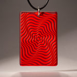 Sandcarved red and red transparent glass vortex pendant.