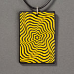 Sandcarved yellow and black glass vortex pendant.
