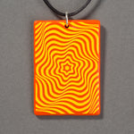 Sandcarved yellow and orange glass vortex pendant.