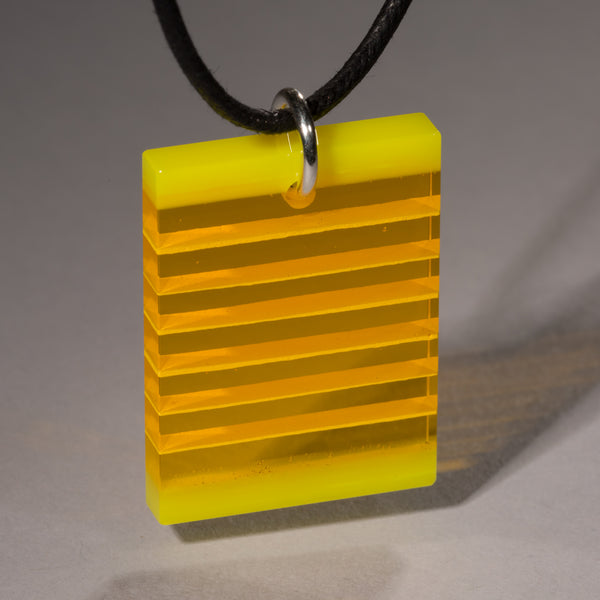 Cut and polished yellow glass layer pendant.