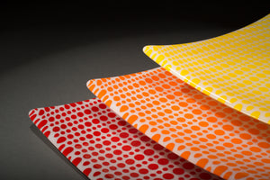 Red, orange, and yellow enamel on white glass circle party plates