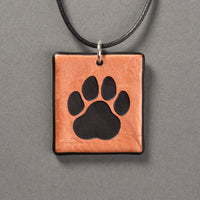 Sandcarved copper and black glass cat paw pendant.