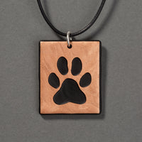 Sandcarved bronze and black glass dog paw pendant.