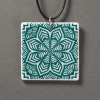 Sandcarved aquamarine and white glass flower mandala pendant.