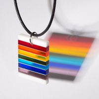 Cut and polished rainbow and white glass pendant.