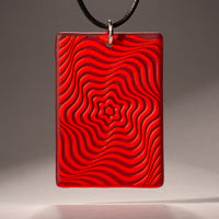 Sandcarved red and red transparent glass vortex pendant.